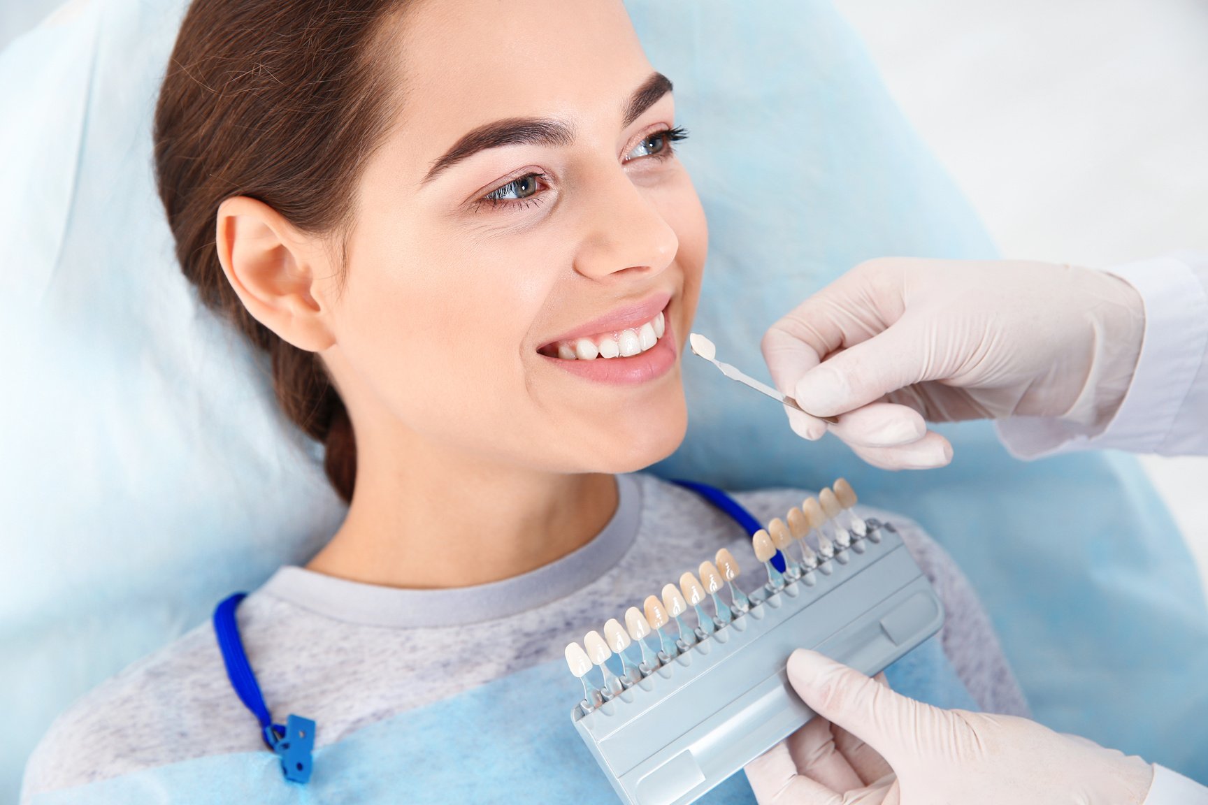 Dentist Selecting Patient's Teeth Color with Palette in Clinic